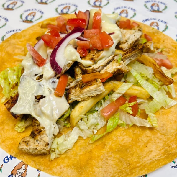 Greek Lady chicken gyro with fries, lettuce, tomatoes, red onions, and white sauce on a tortilla.